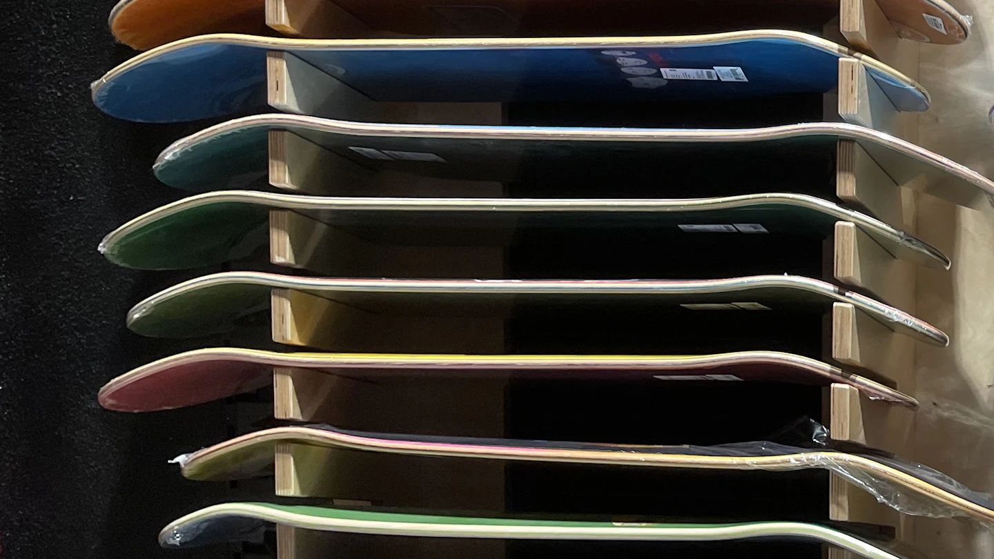 Skate shop display with decks of different colours stacked horizontally